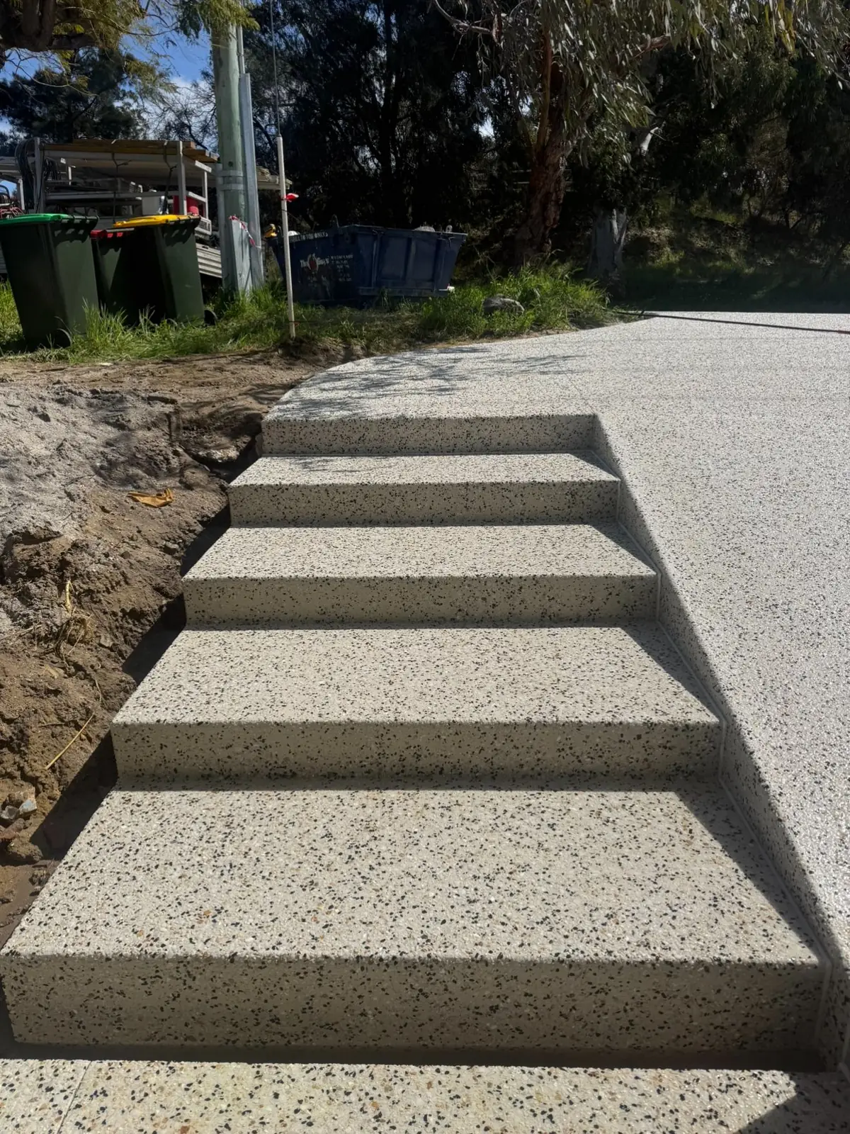 Exposed aggregate stairs stepping down from a driveway